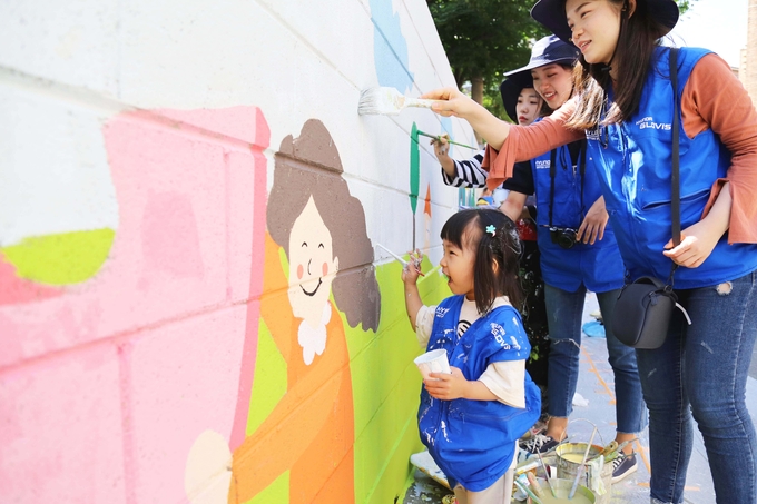 ‘안전공감 벽화 그리기’ 행사에 참여한 현대글로비스 직원과 가족, 대학생 홍보대사 영글로비스가 함께 안전을 주제로 한 벽화를 그리고 있다. (사진제공 : 현대글로비스)